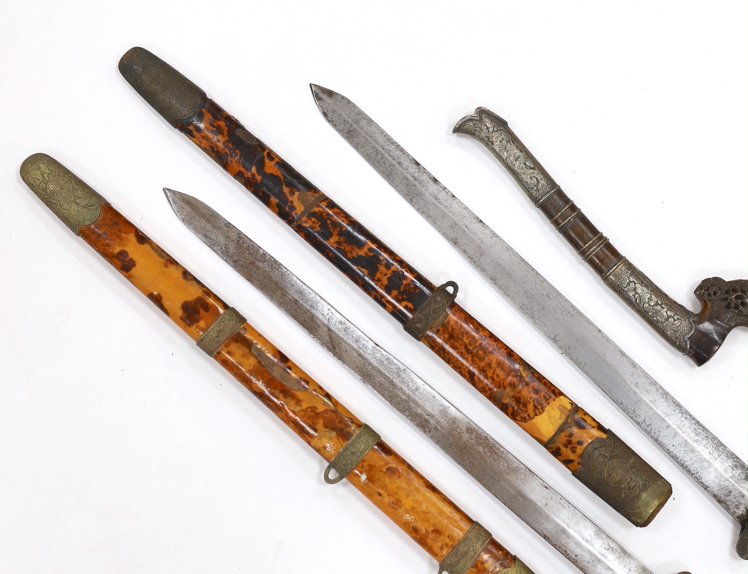 Two Chinese short swords (Jian) in faux tortoiseshell veneered scabbards and a Sumatran knife dagger with sheath (sekin), blade 42cm